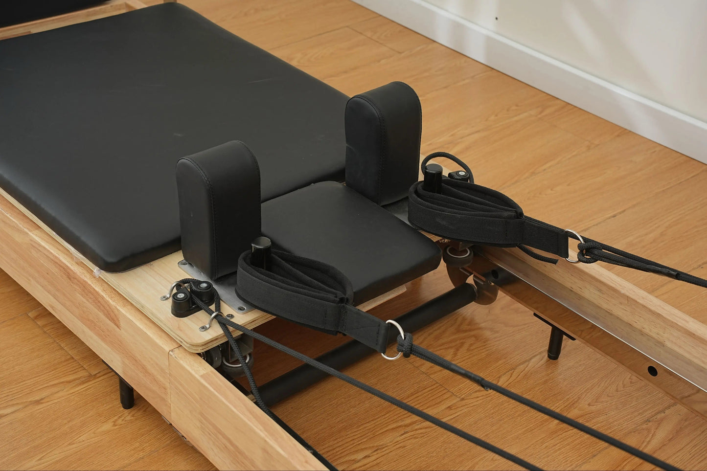 Foldable oak Pilates reformer, designed for small spaces and easy storage.