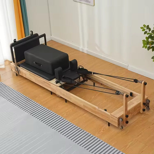 Space-saving foldable oak Pilates reformer, perfect for home gyms and compact spaces.